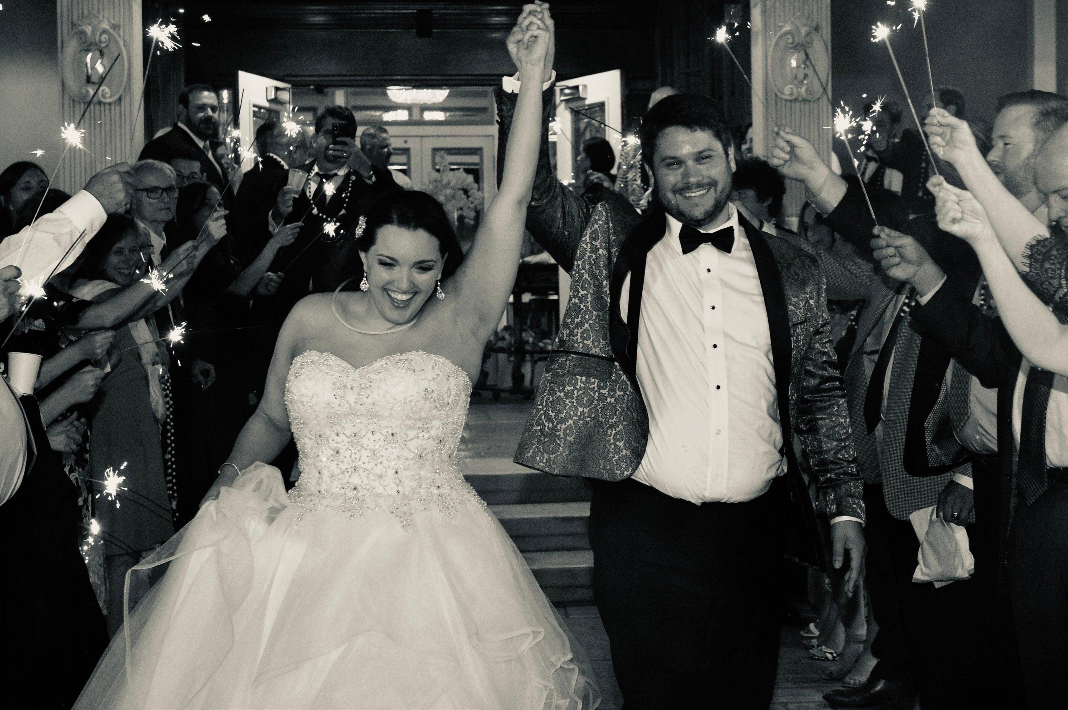 Wedding couple celebrating with sparklers in a crowded indoor setting
