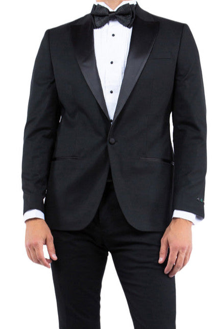 Man wearing a black tuxedo with a white shirt and bow tie on a white background