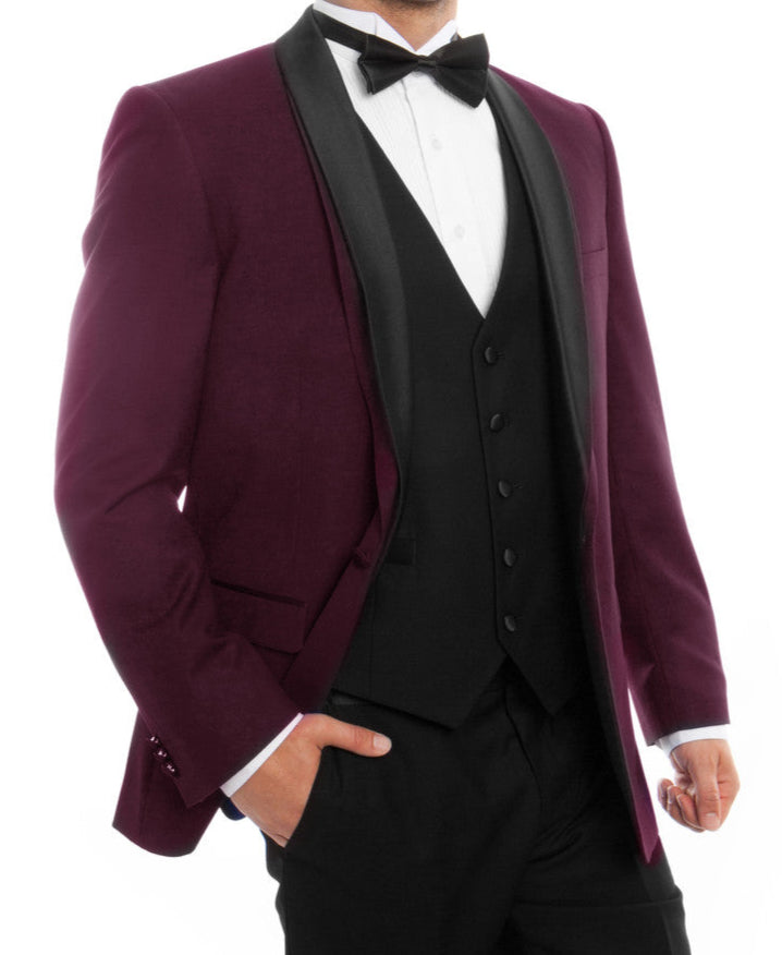 Man wearing a burgundy tuxedo with a black bow tie on a white background