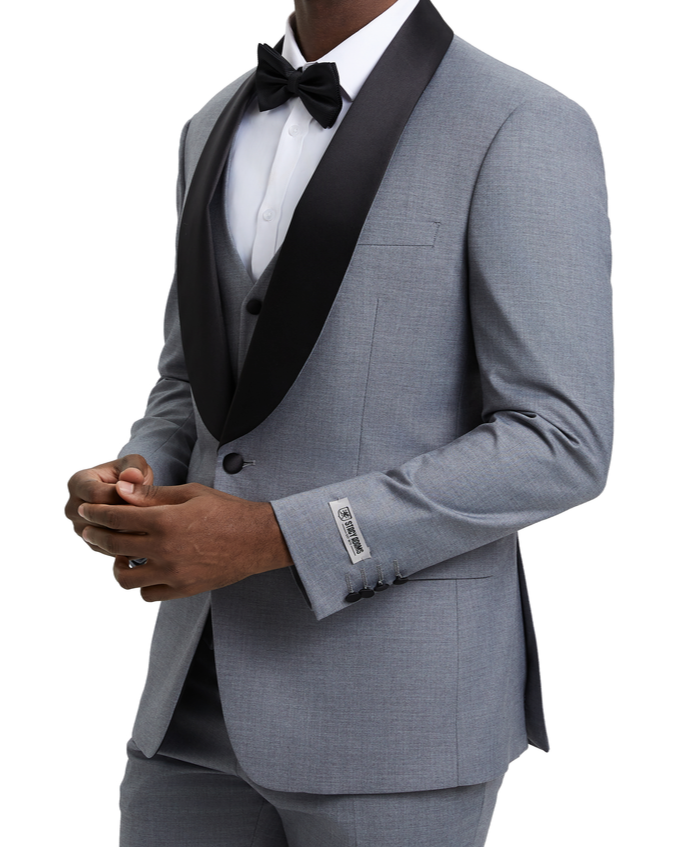Man wearing a gray tuxedo with a black bow tie on a white background